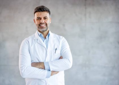 Photo of confident male doctor in hospital, looking at camera with smile. Photo of confident male doctor in hospital, looking at camera with smile.